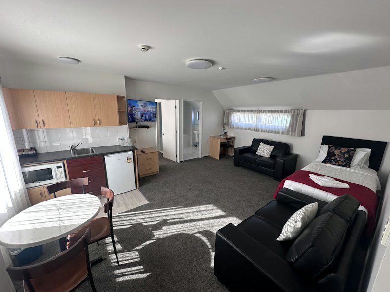 One-Bedroom Deluxe Apartment lounge with kitchenette and dining table