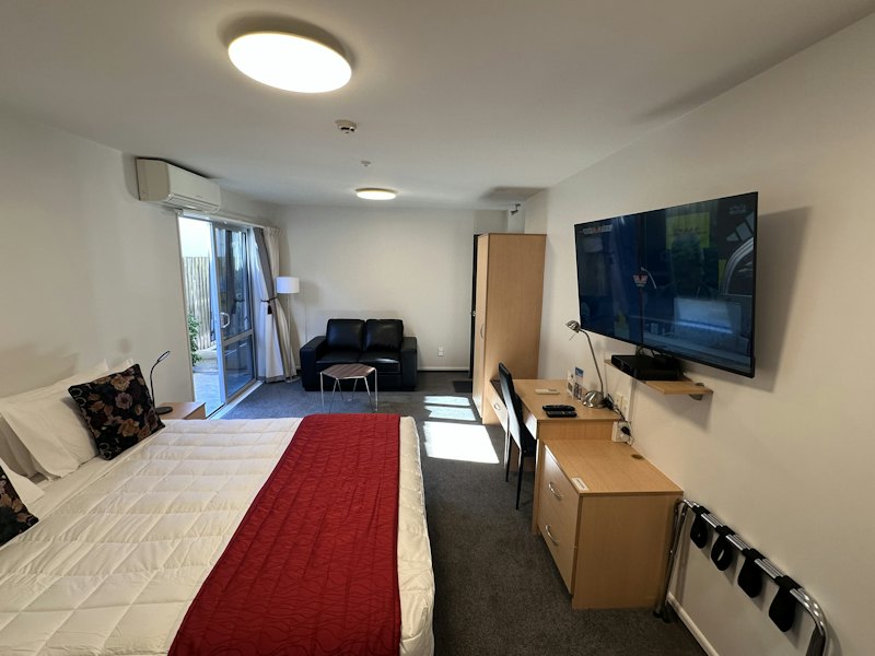 Superior Studio with king bed, patio door, sofa and TV