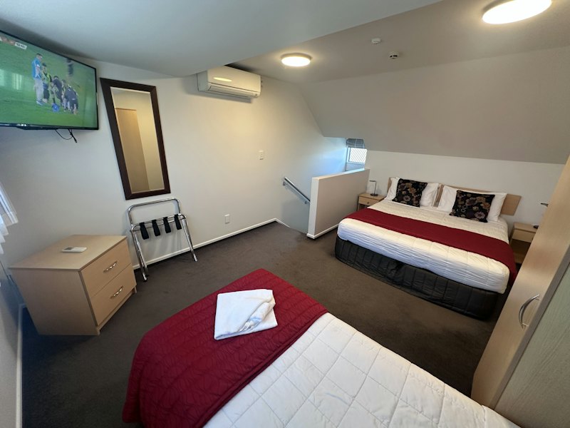 Upstairs bedroom with two beds in the Split Level Apartment